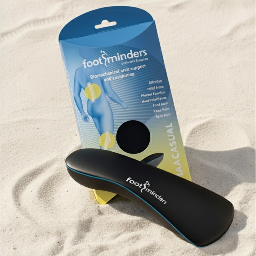 Black orthotic insole with 'foot minders' packaging on sand